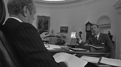 President Gerald Ford and Baker talking at a desk