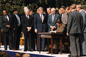 President Reagan sitting at table signing document