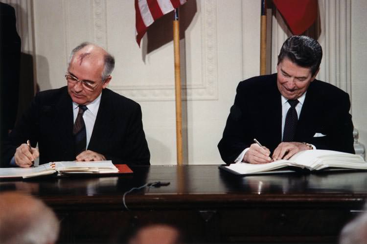Soviet leader Gorbachev and President Reagan signing documents
